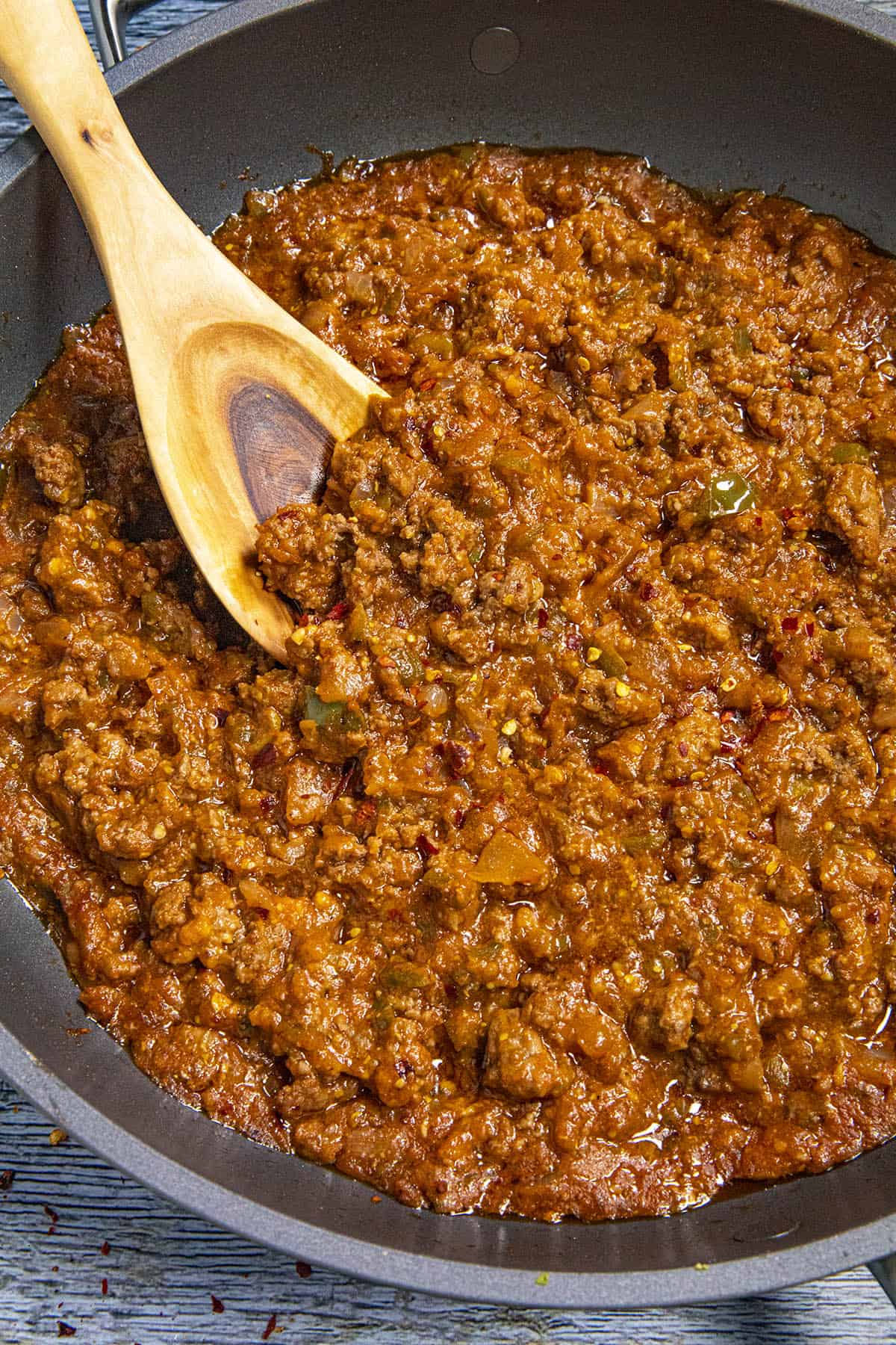 Mike scooping up Sloppy Joes from the pan with a spoon