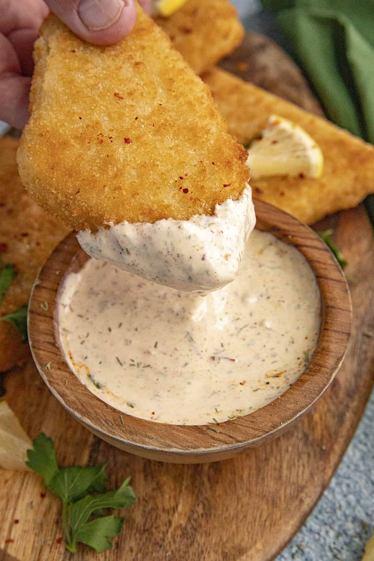 Mike dipping his fried fish into a bowl of Tartar Sauce