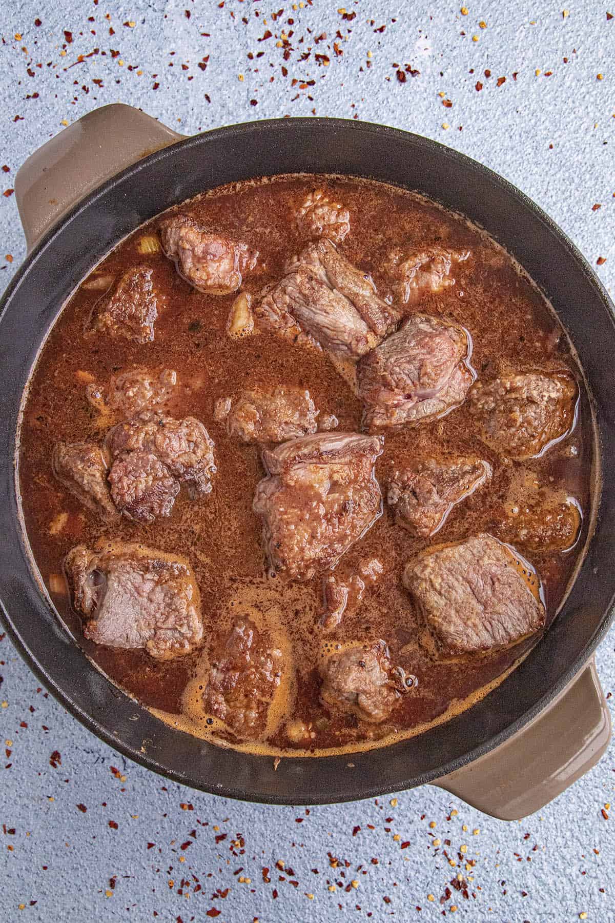 Simmering the beef chunks in wine and beef broth