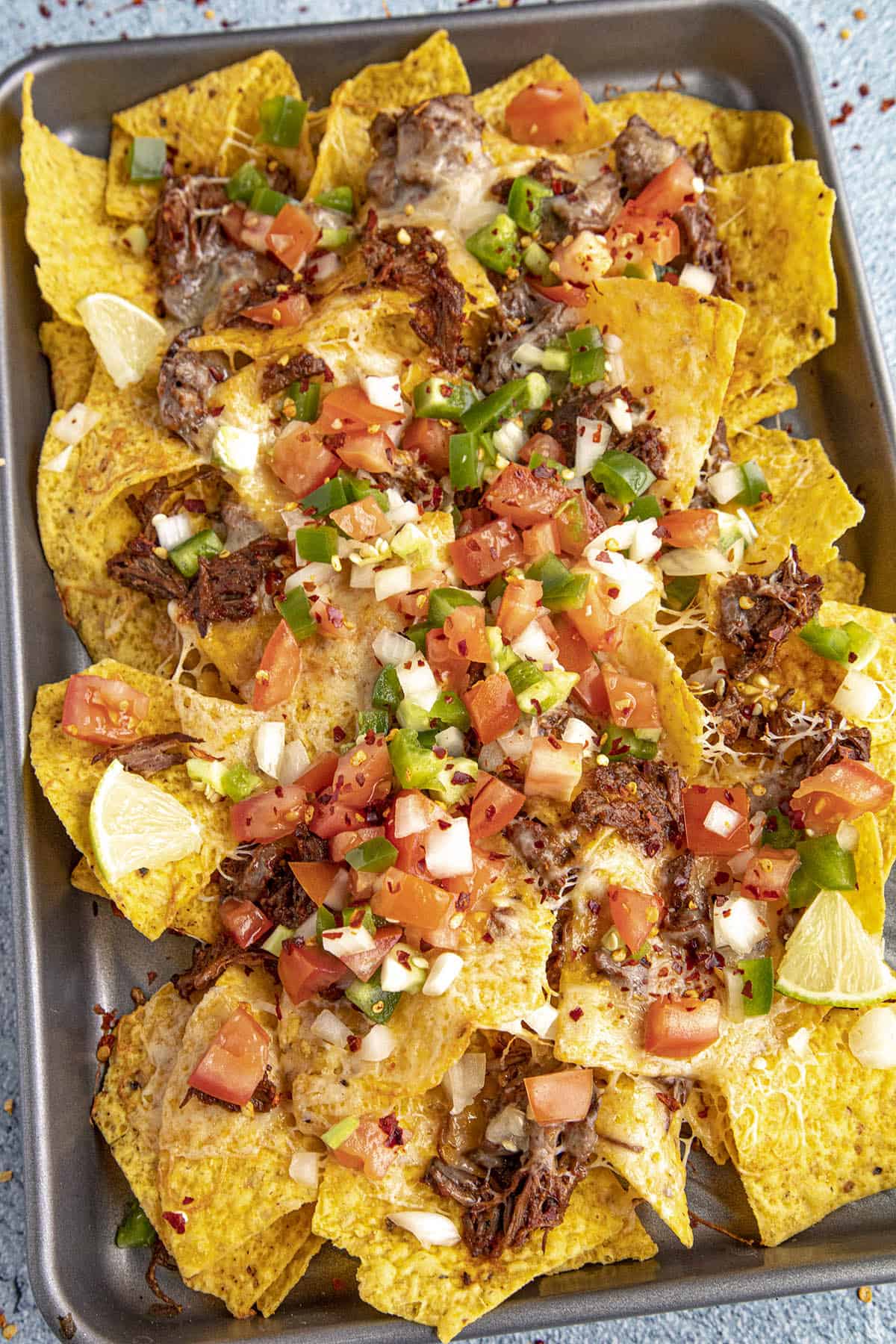 Birria Nachos on a tray topped with homemade pico de gallo