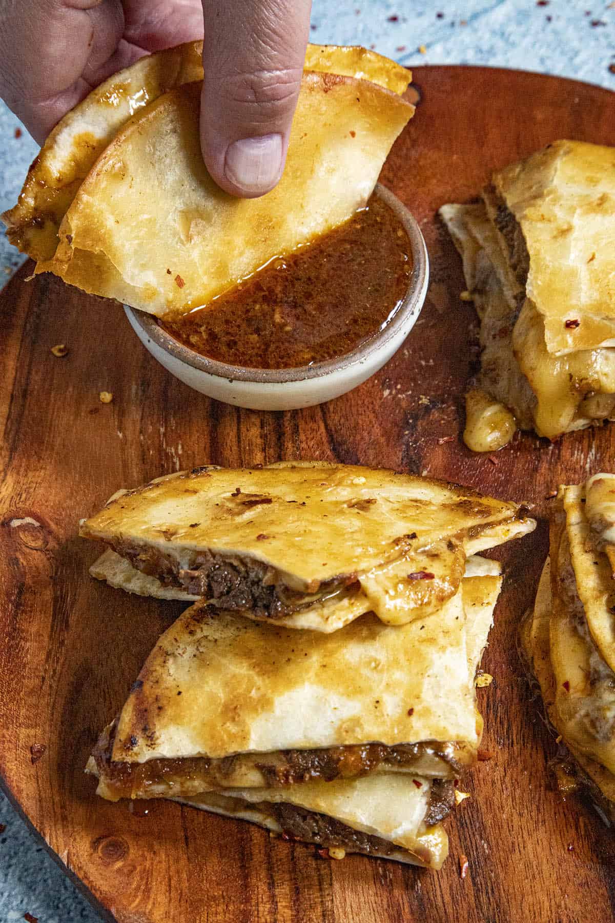 Dipping a Birria Quesadilla into the birria consome