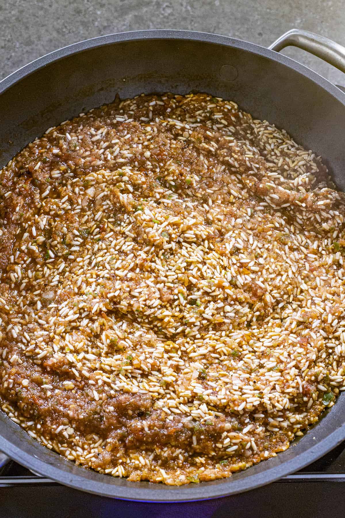 Cooking the Mexican rice ingredients in a pan, before adding liquid