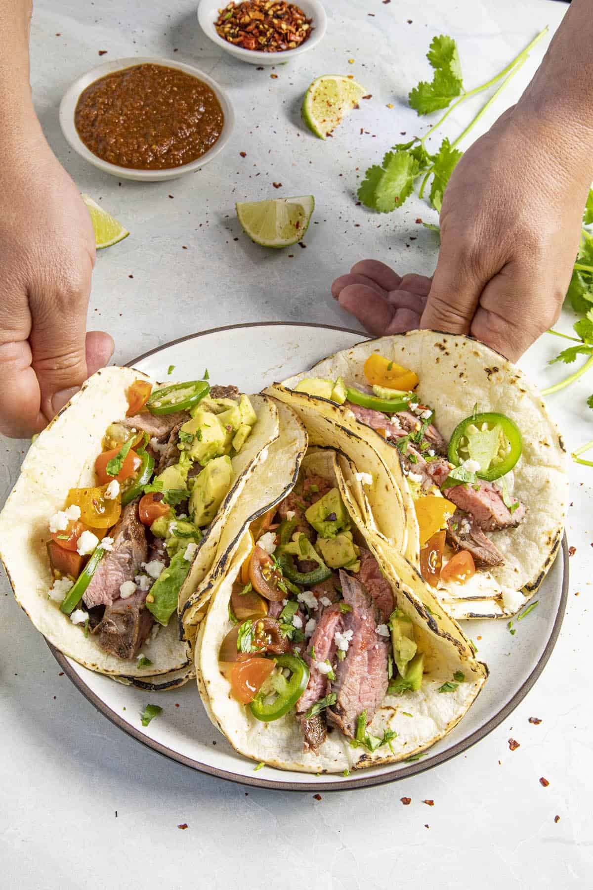 Mike setting a plate of Carne Asada Tacos on the table