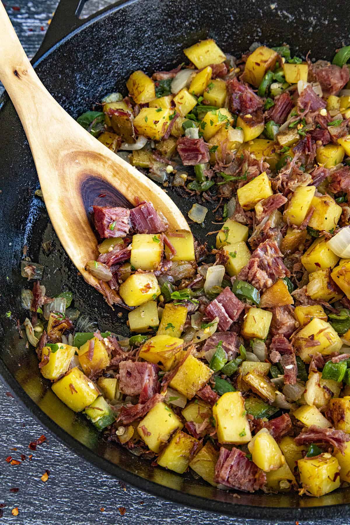 Scooping a serving of Corned Beef Hash from the hot pan