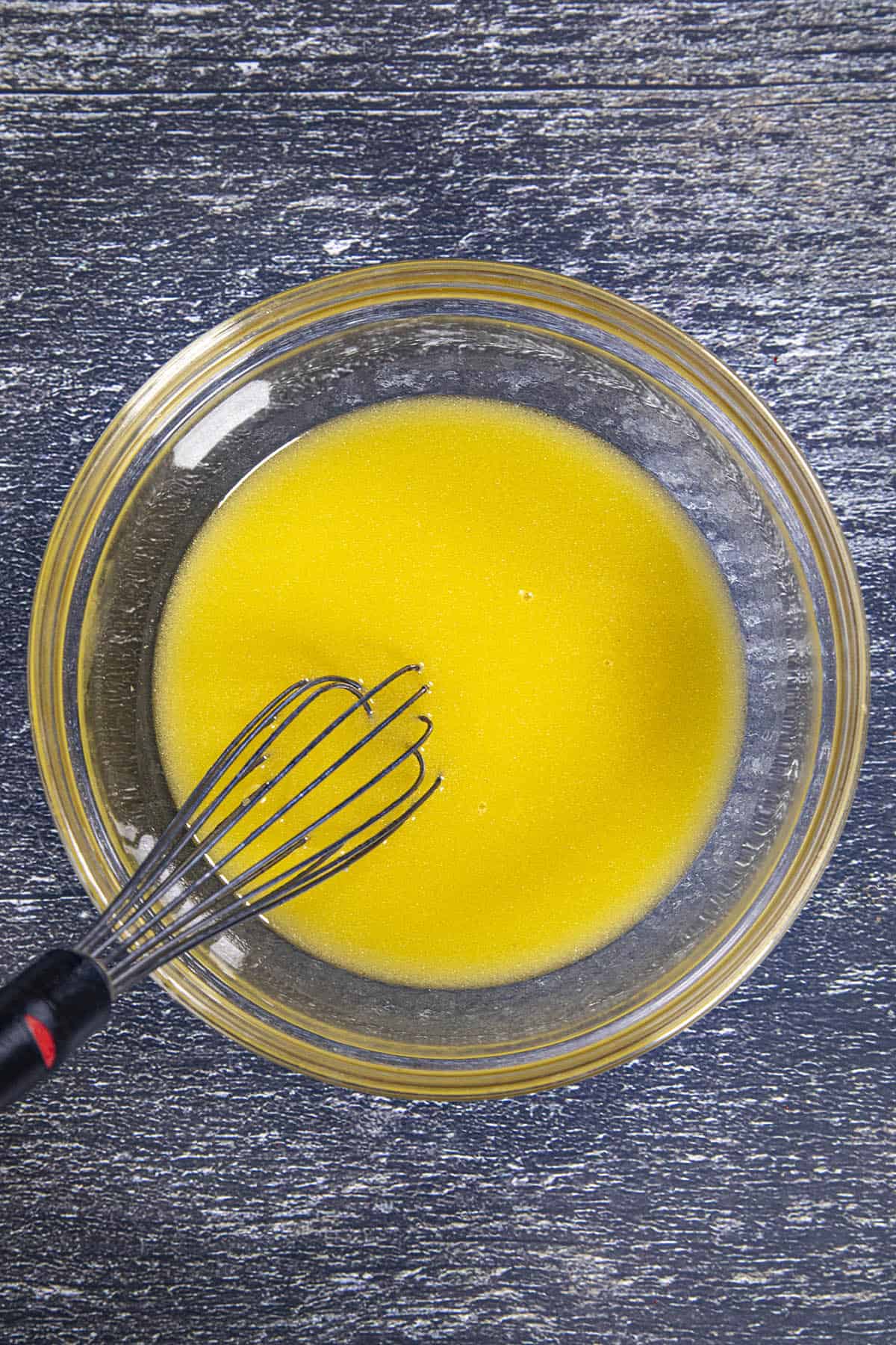 Whisking sour orange juice and olive oil to make Mojo Marinade