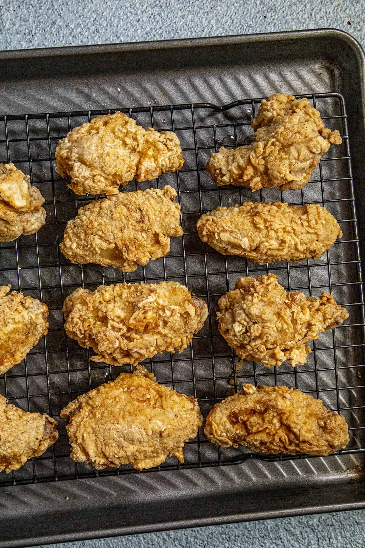 Fried Chicken Wings draining on a wire rack