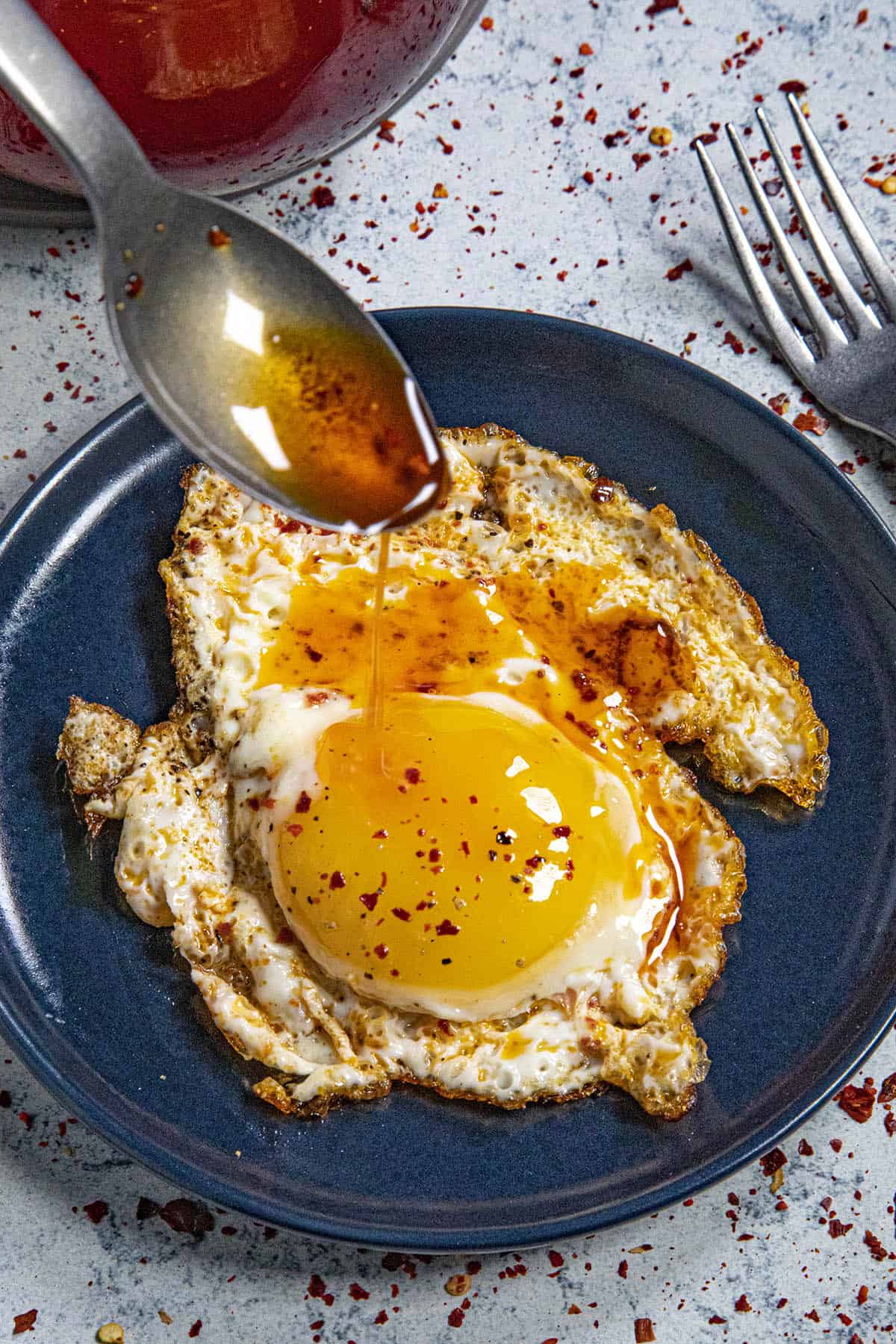 Drizzling homemade chili oil over a fried egg