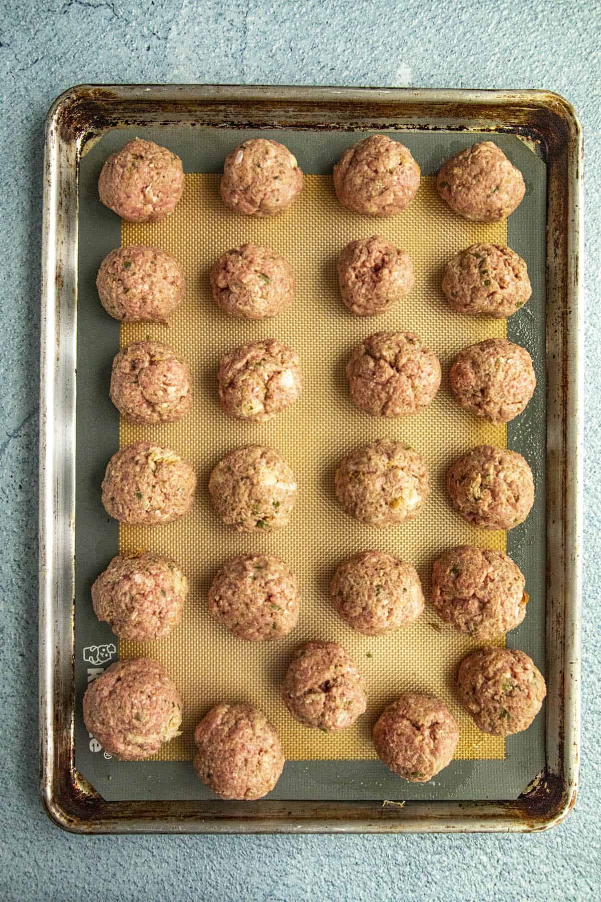 Meatballs on a baking sheet, ready for the oven
