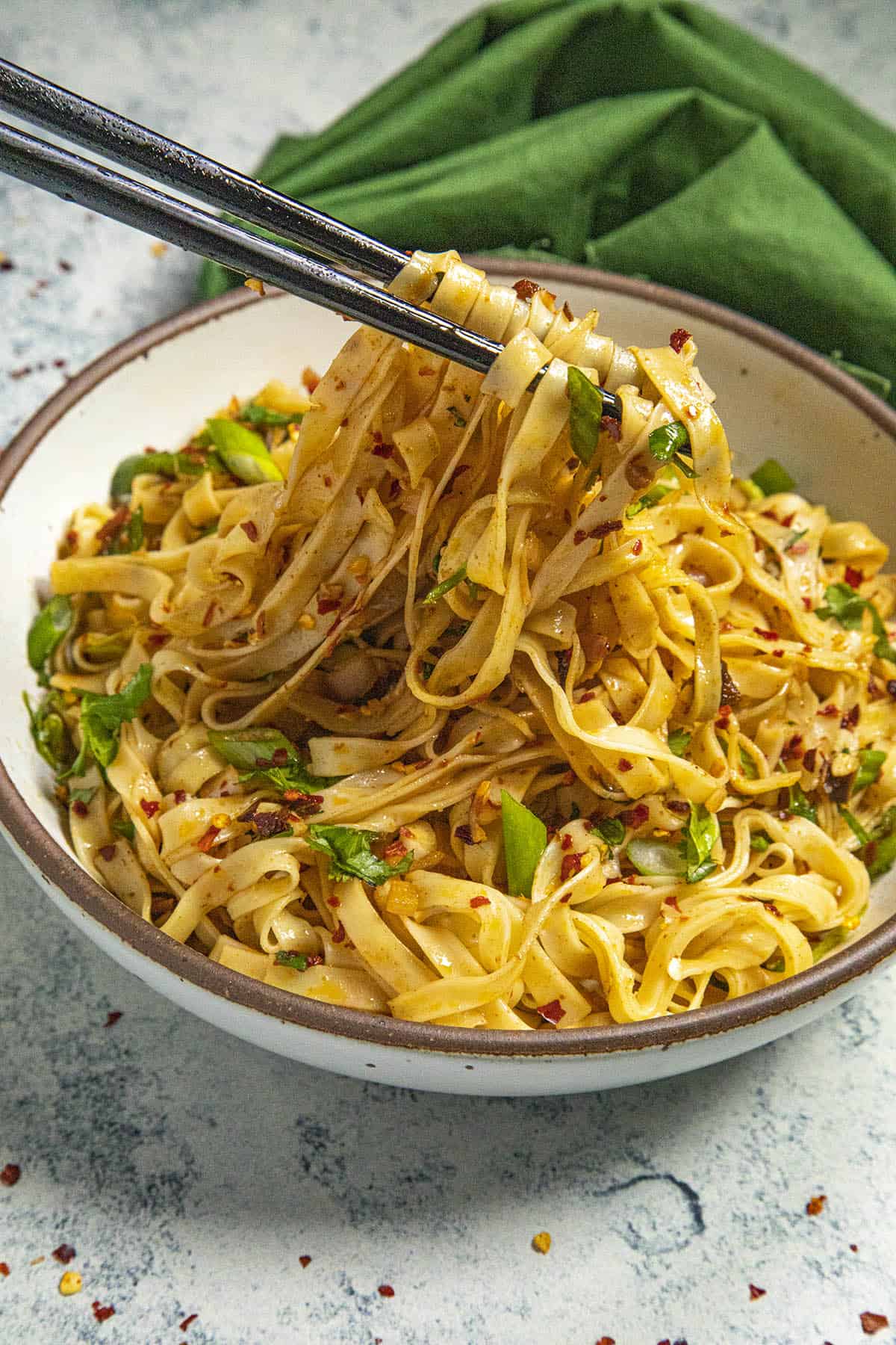 Mike taking chili oil noodles from the bowl with chopsticks