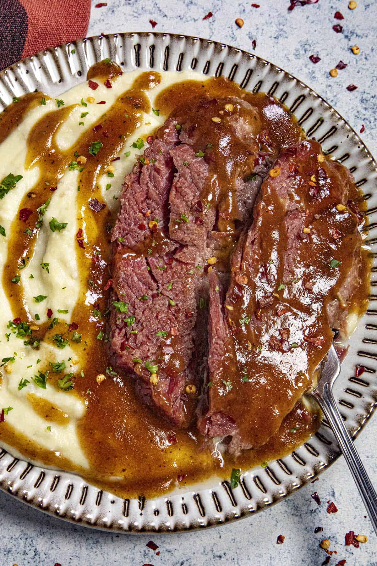 Sliced Corned Beef on a plate with Guinness Gravy and Mashed Potatoes