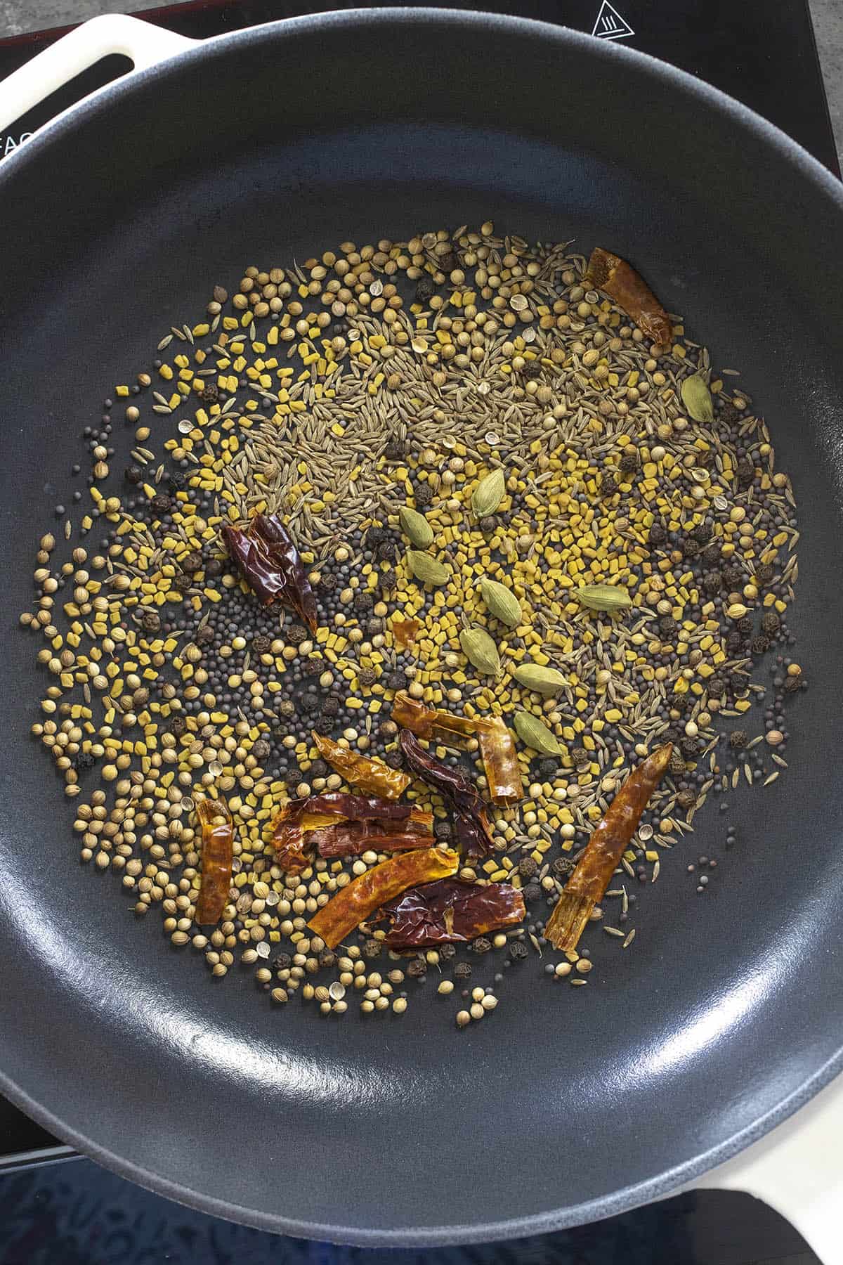 Toasting whole seeds and pods in a pan to make Homemade Curry Powder