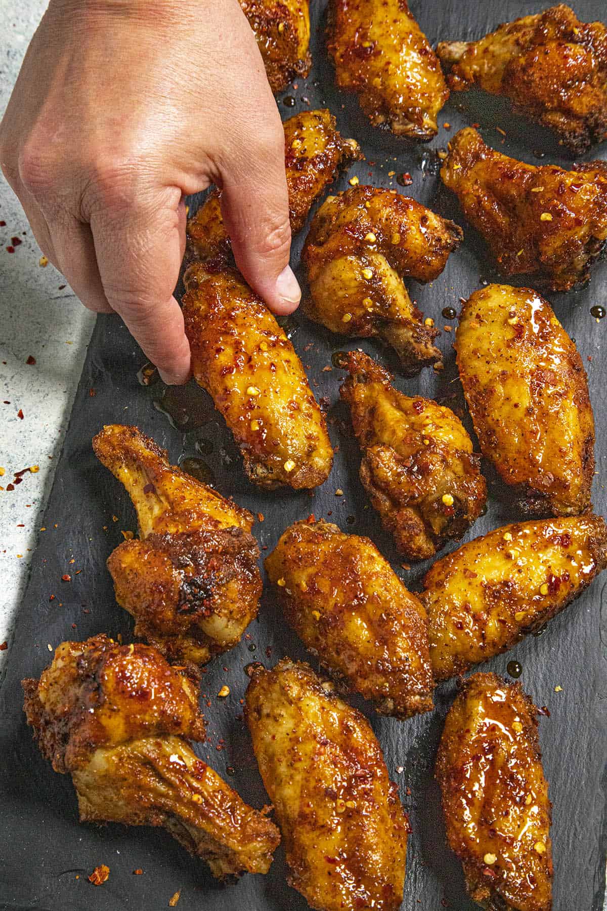 Mike taking a hot honey chicken wing from the platter