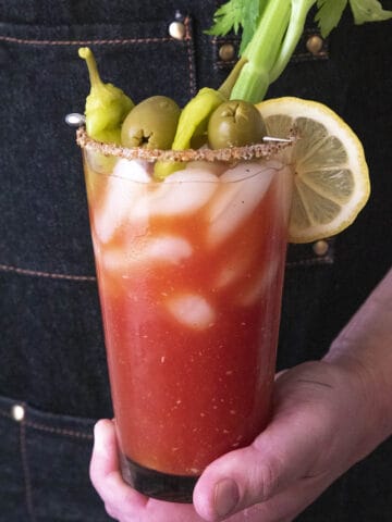 Holding a glass with Spicy Blood Mary