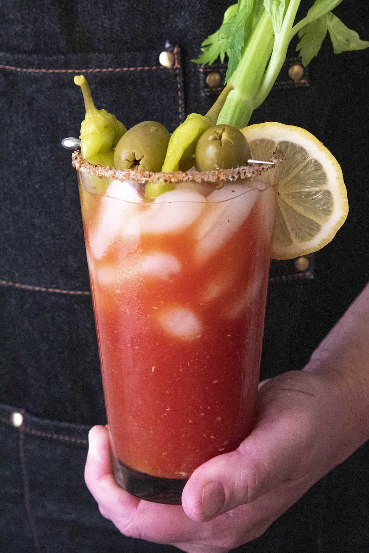 Holding a glass with Spicy Blood Mary