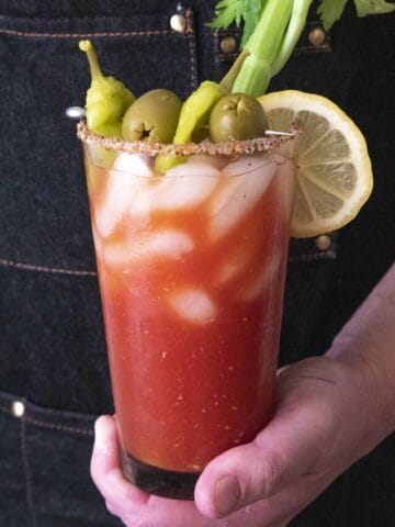 Holding a glass with Spicy Blood Mary