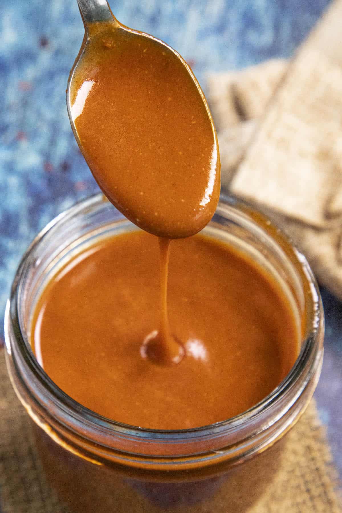 Thick, spicy, tangy Homemade Buffalo Sauce dripping from a spoon