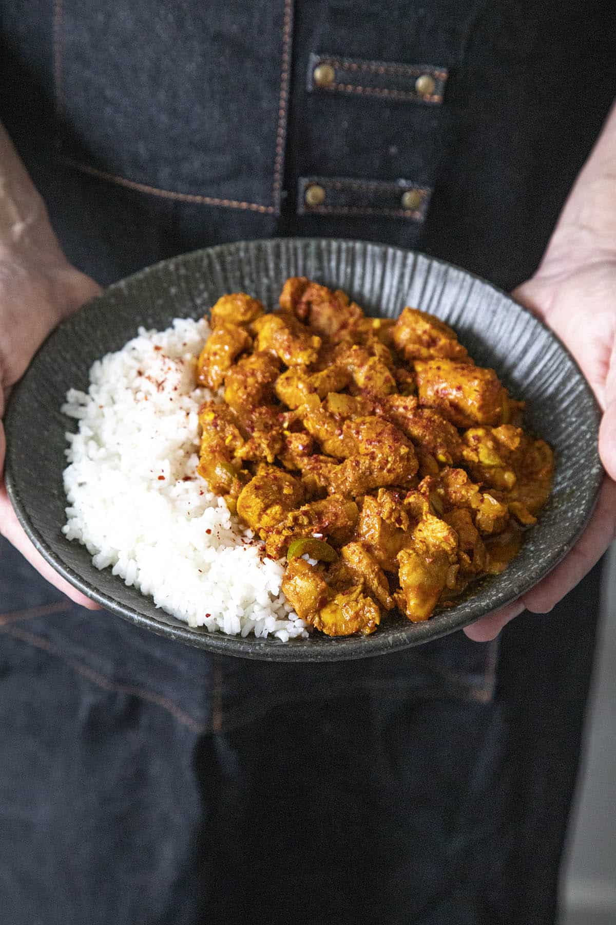 Mike holding a plate of Chicken Vindaloo with white rice