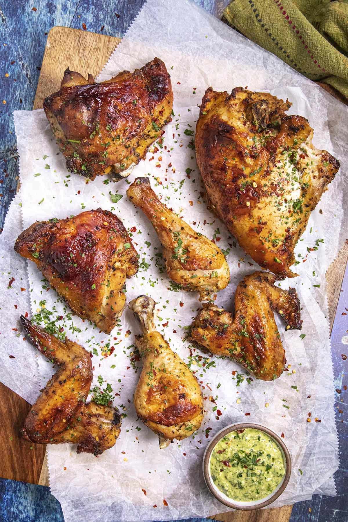 Pieces of Peruvian Chicken (Pollo a la Brasa) on a platter with aji verde sauce