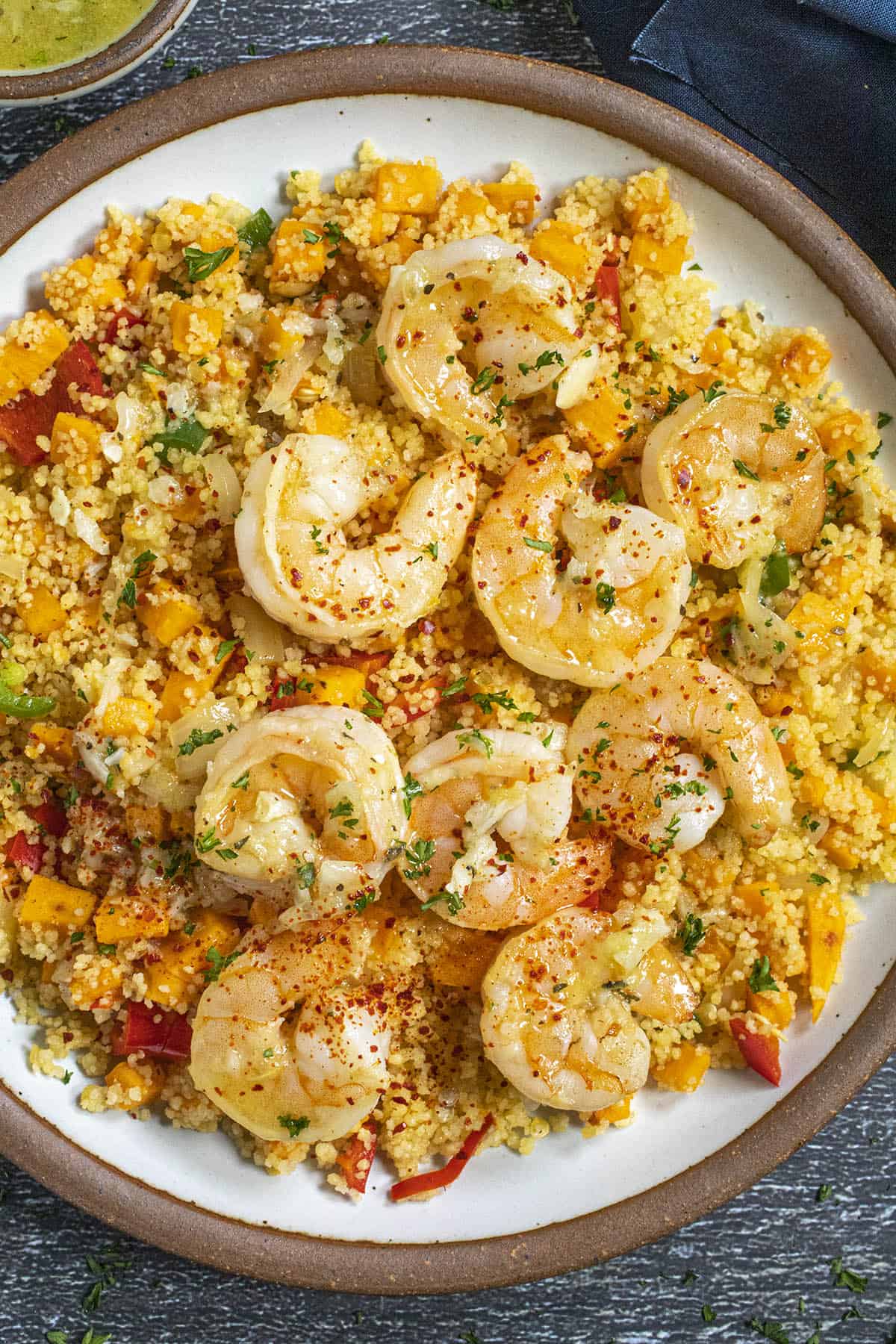 A bowl of Mojo Shrimp served over couscous loaded with chopped bell pepper and sweet potato