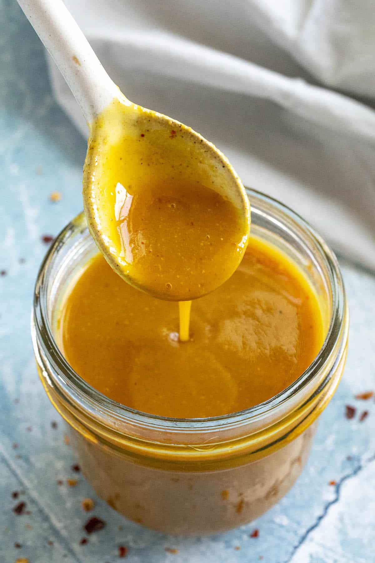 Tangy Carolina Gold BBQ Sauce dripping from a spoon