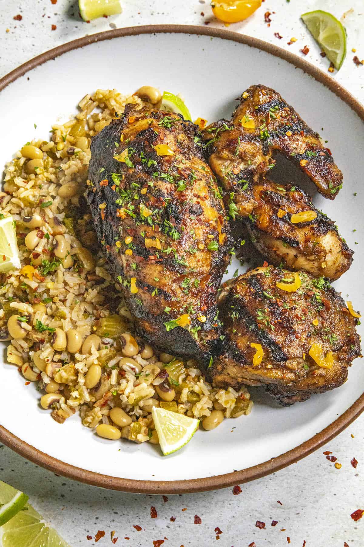 Jamaican Jerk Chicken served on a plate with Jamaican rice and peas
