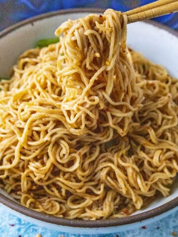Lifting Thai Peanut Noodles from a bowl with chopsticks