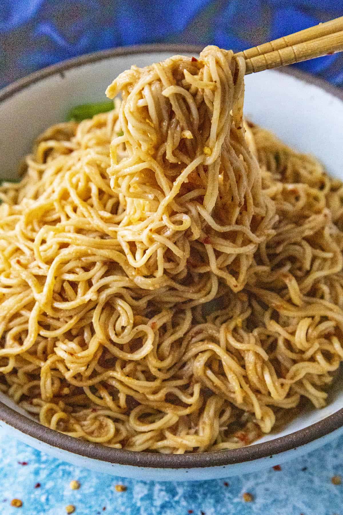 Lifting Thai Peanut Noodles from a bowl with chopsticks