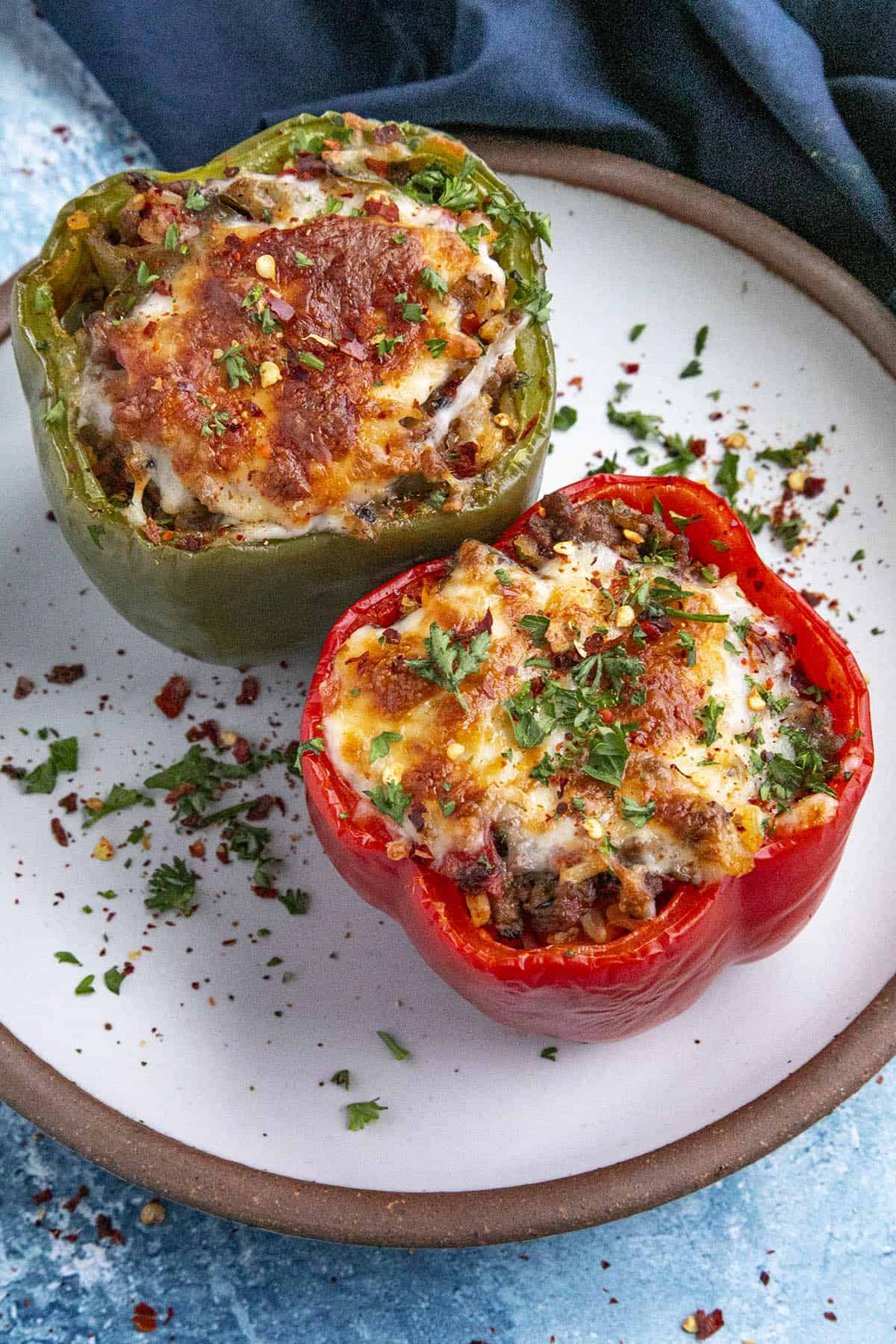 Two stuffed bell peppers on a serving plate