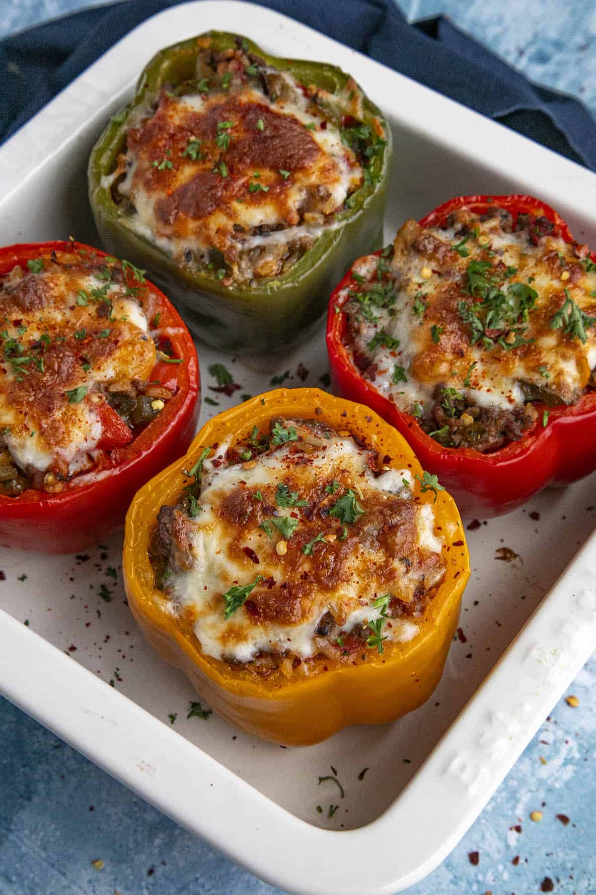 4 stuffed bell peppers out of the oven with melty cheese on top, ready to serve