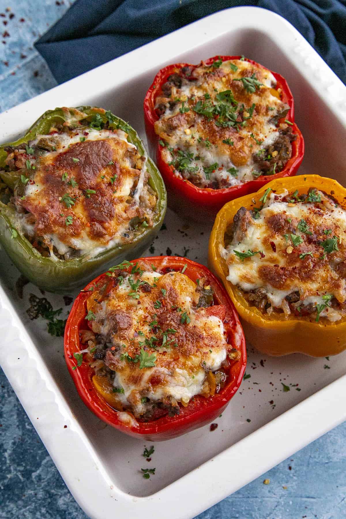 4 stuffed bell peppers out of the oven with melty cheese on top