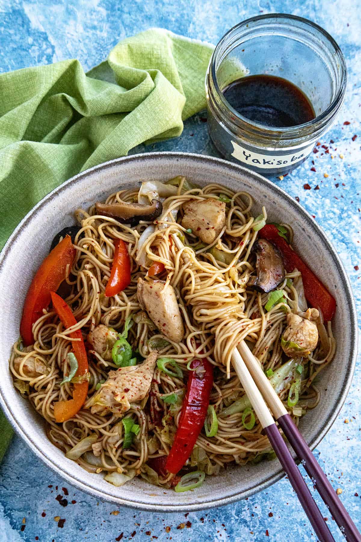 Yakisoba noodles in a bowl with yakisoba sauce on the side