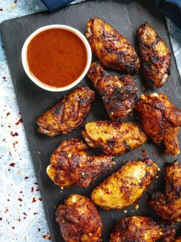 Honey Sriracha Sauce on a platter with grilled chicken wings