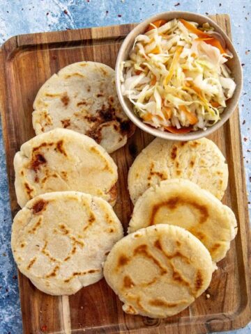 Salvadoran pupusas on a platter with curtido, or cabbage relish