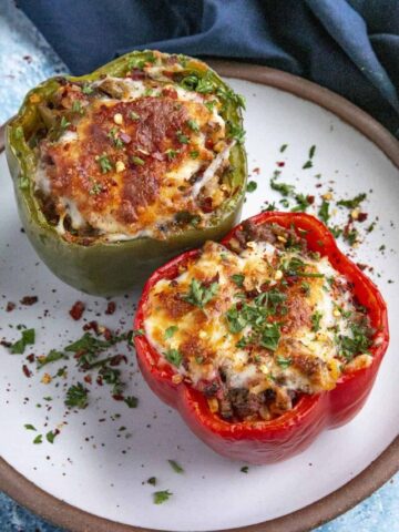 Two stuffed bell peppers on a serving plate