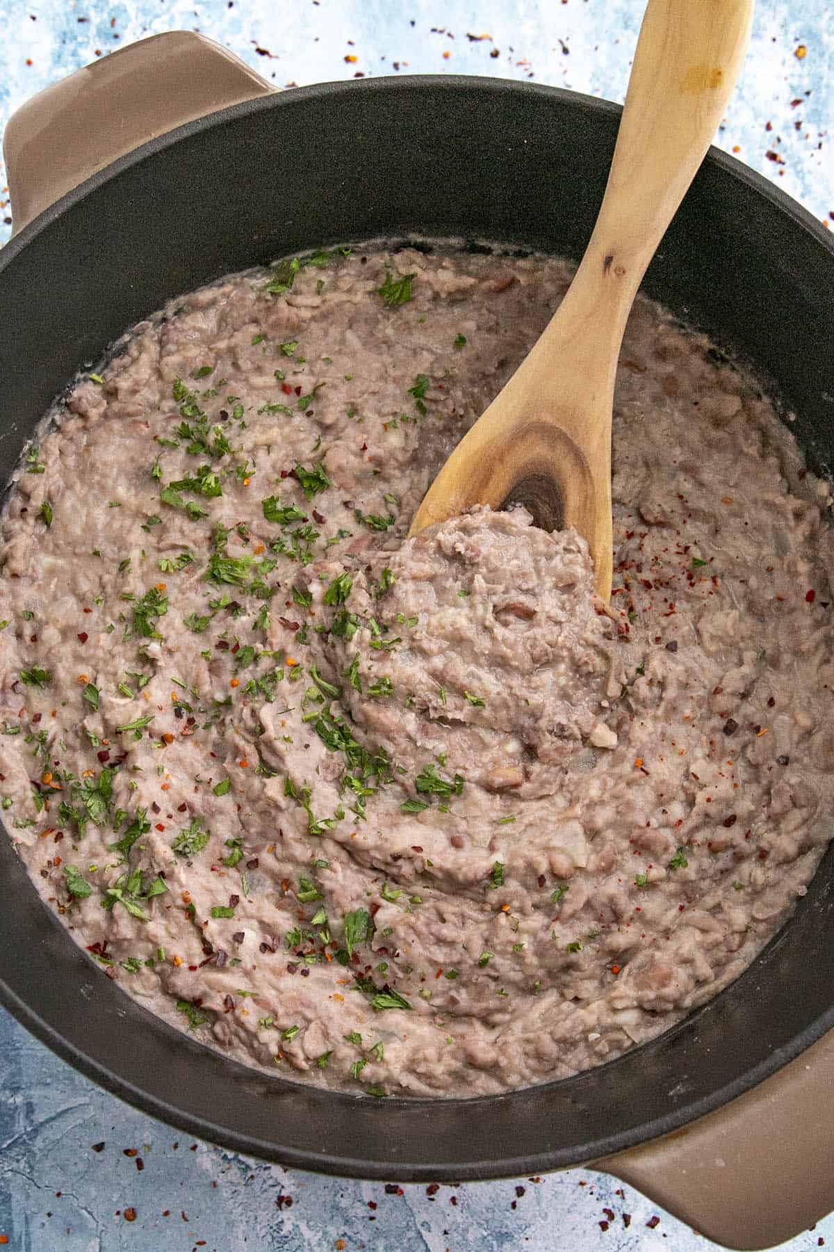 Mike scooping Homemade Refried Beans from the pot