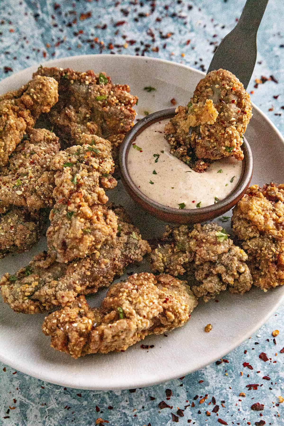 Mike dipping a crispy fried oyster into remoulade