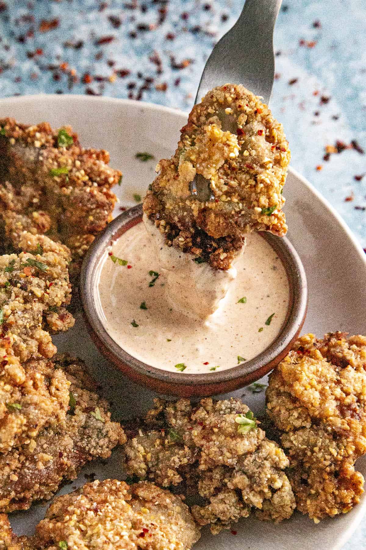 Dipping a fried oyster into homemade remoulade sauce