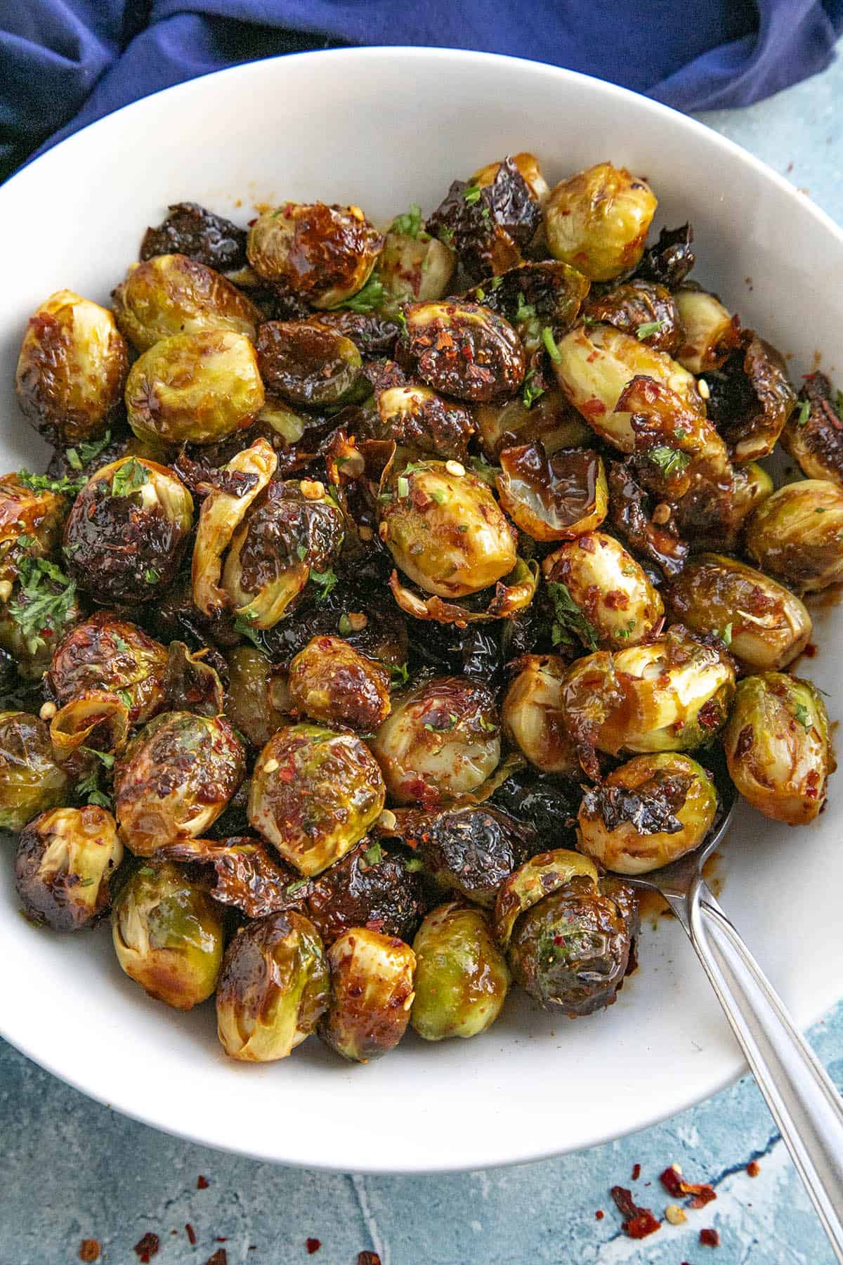 Sweet and spicy Honey Sriracha Brussels Sprouts in a bowl with a spoon