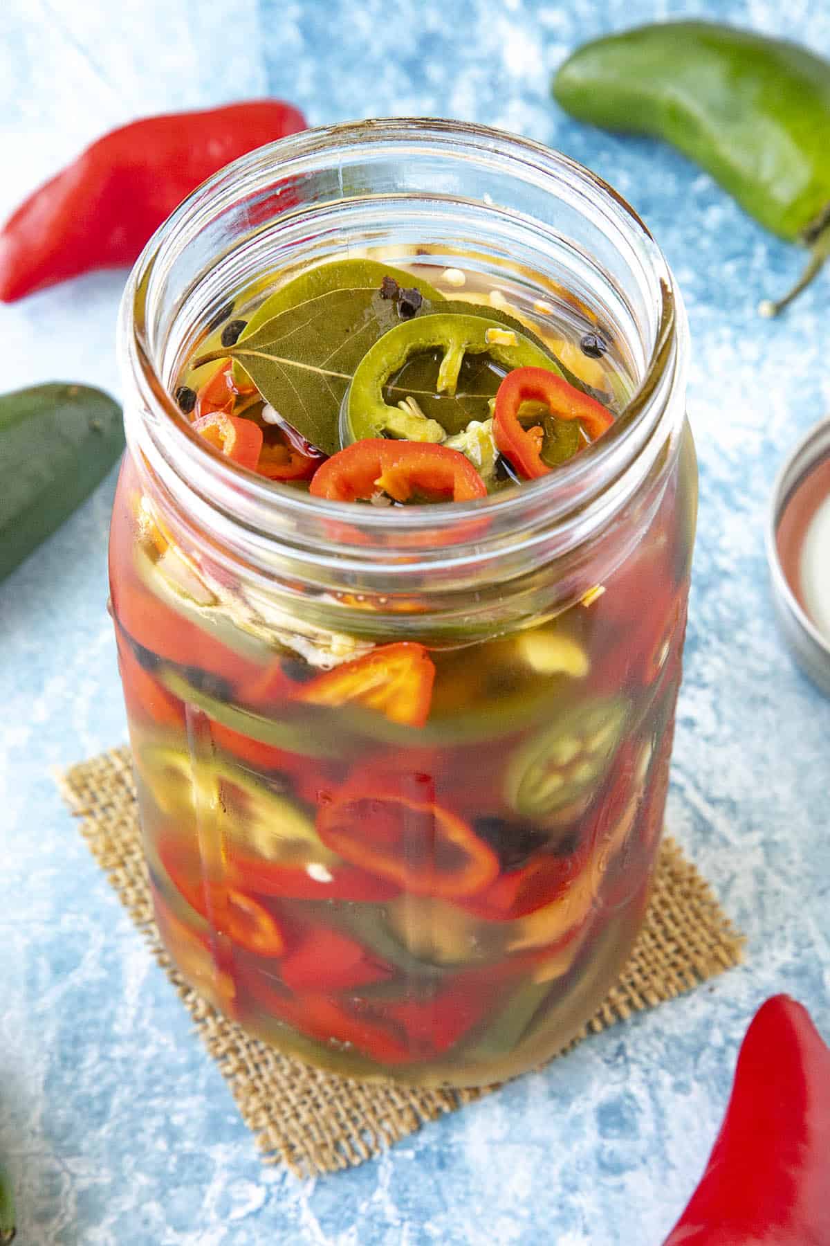 A mix of Pickled peppers in a jar