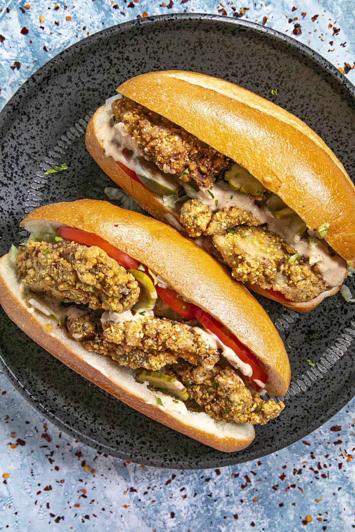 Oyster Po Boy Sandwiches with pickles, tomatoes, and remoulade sauce