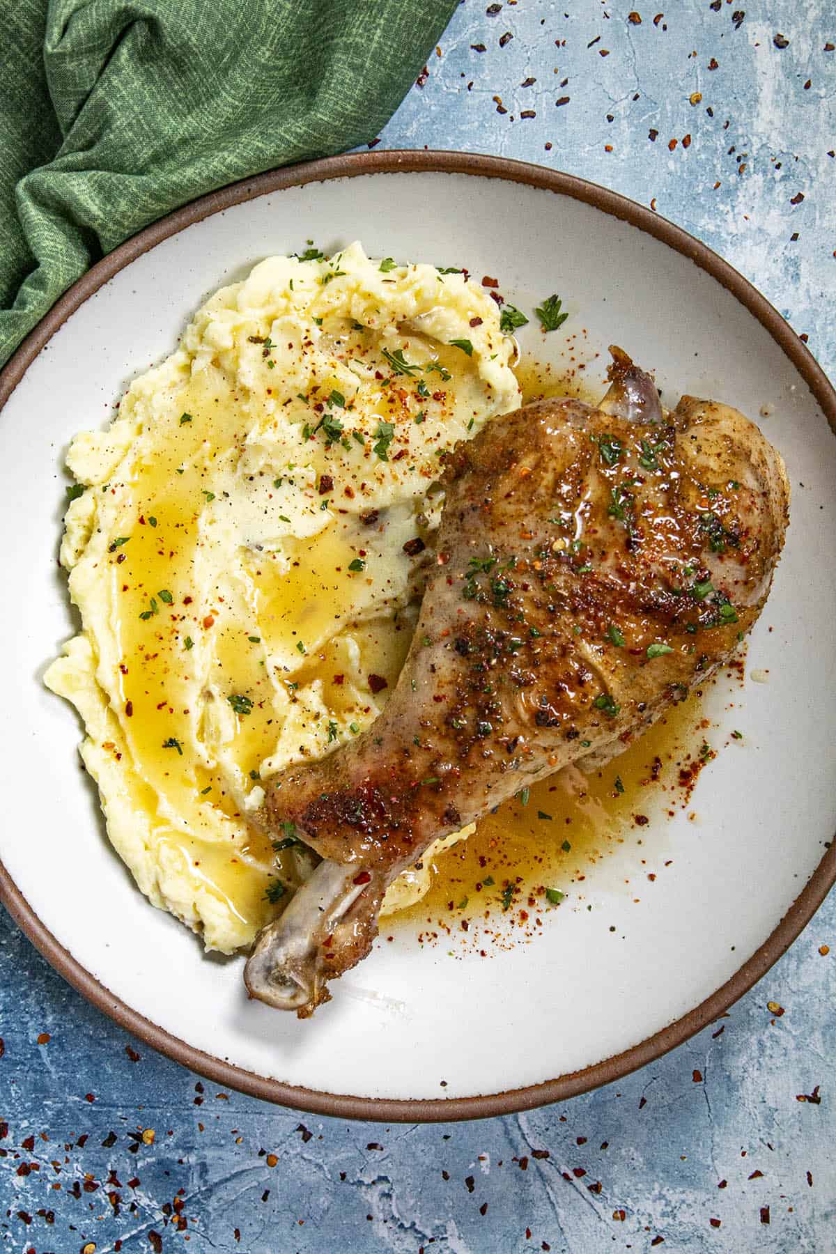 A roasted turkey leg served over mashed potatoes