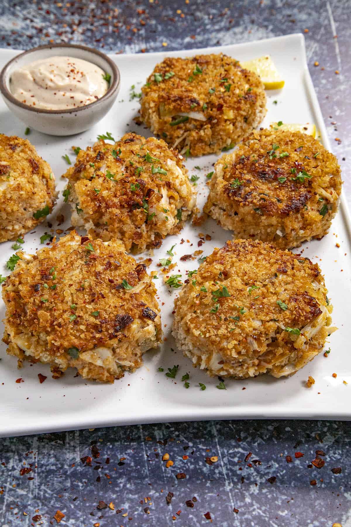 Crab Cakes on a serving platter with creamy crab cake sauce