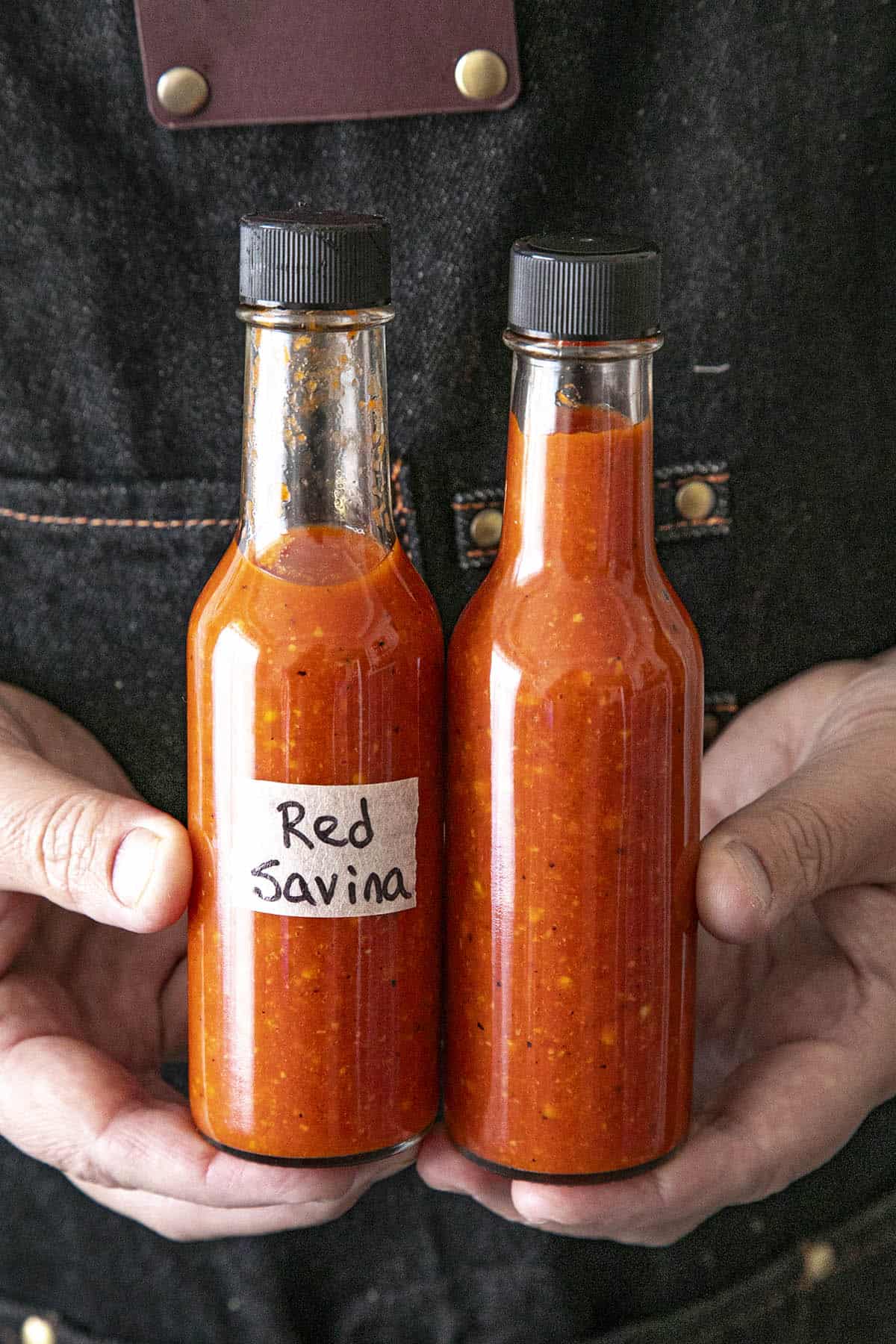 Mike holding a bottle 2 bottles of Red Savina Habanero Hot Sauce