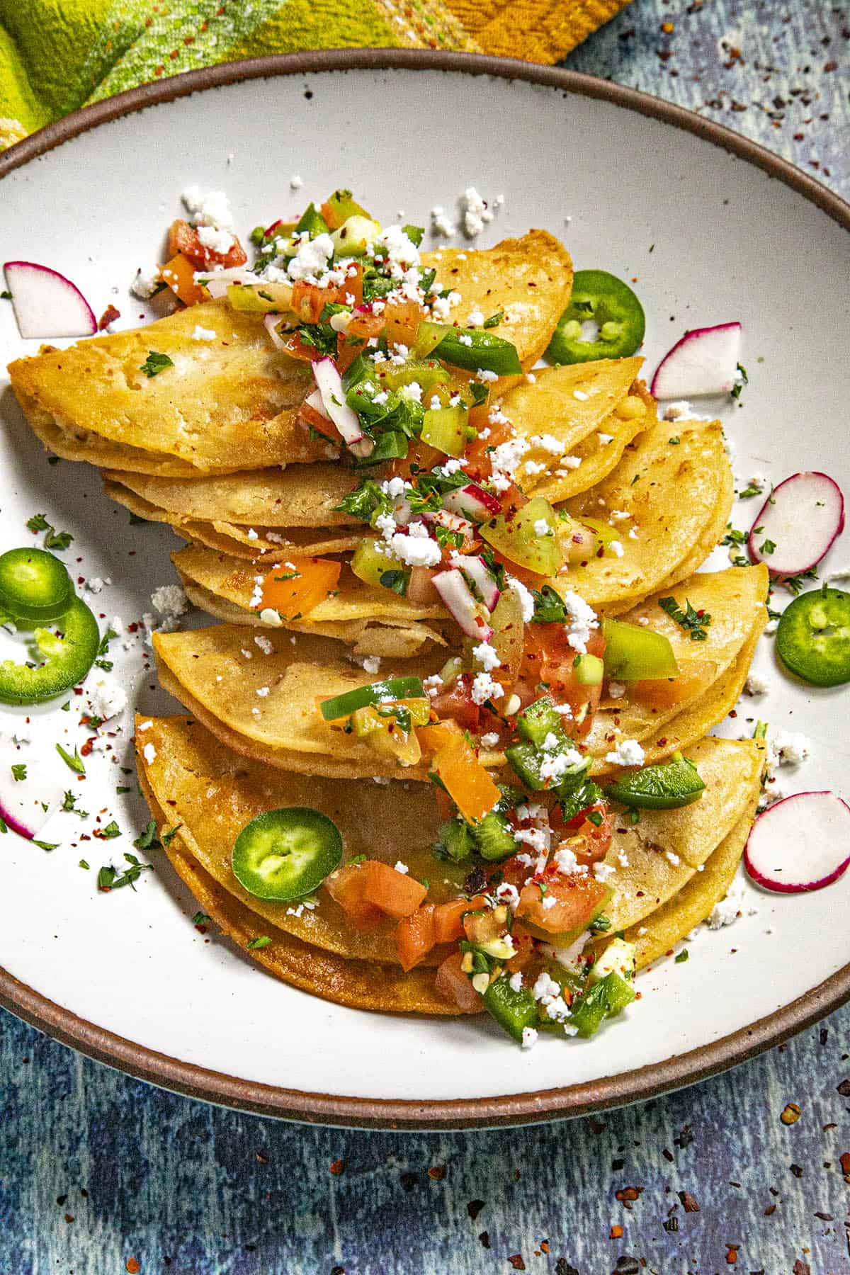 Tacos de Papa covered in salsa and queso fresco