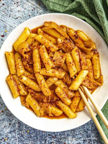 Mike taking a piece Tteokbokki from the bowl