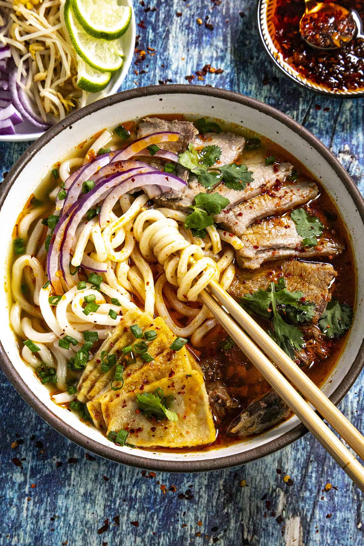 Mike taking noodles from a bowl of bun bo hue