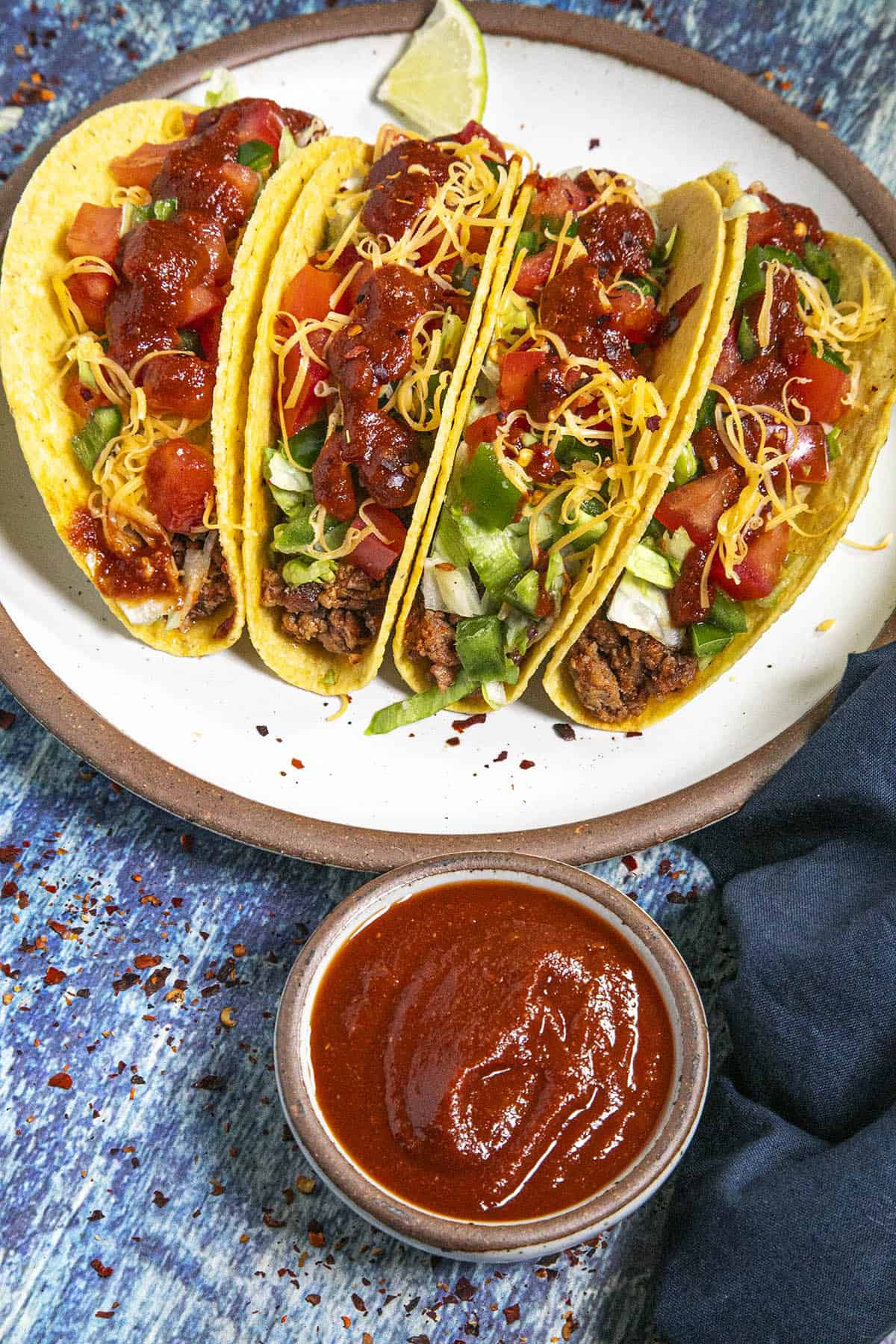 Taco Sauce drizzled onto crunchy tacos
