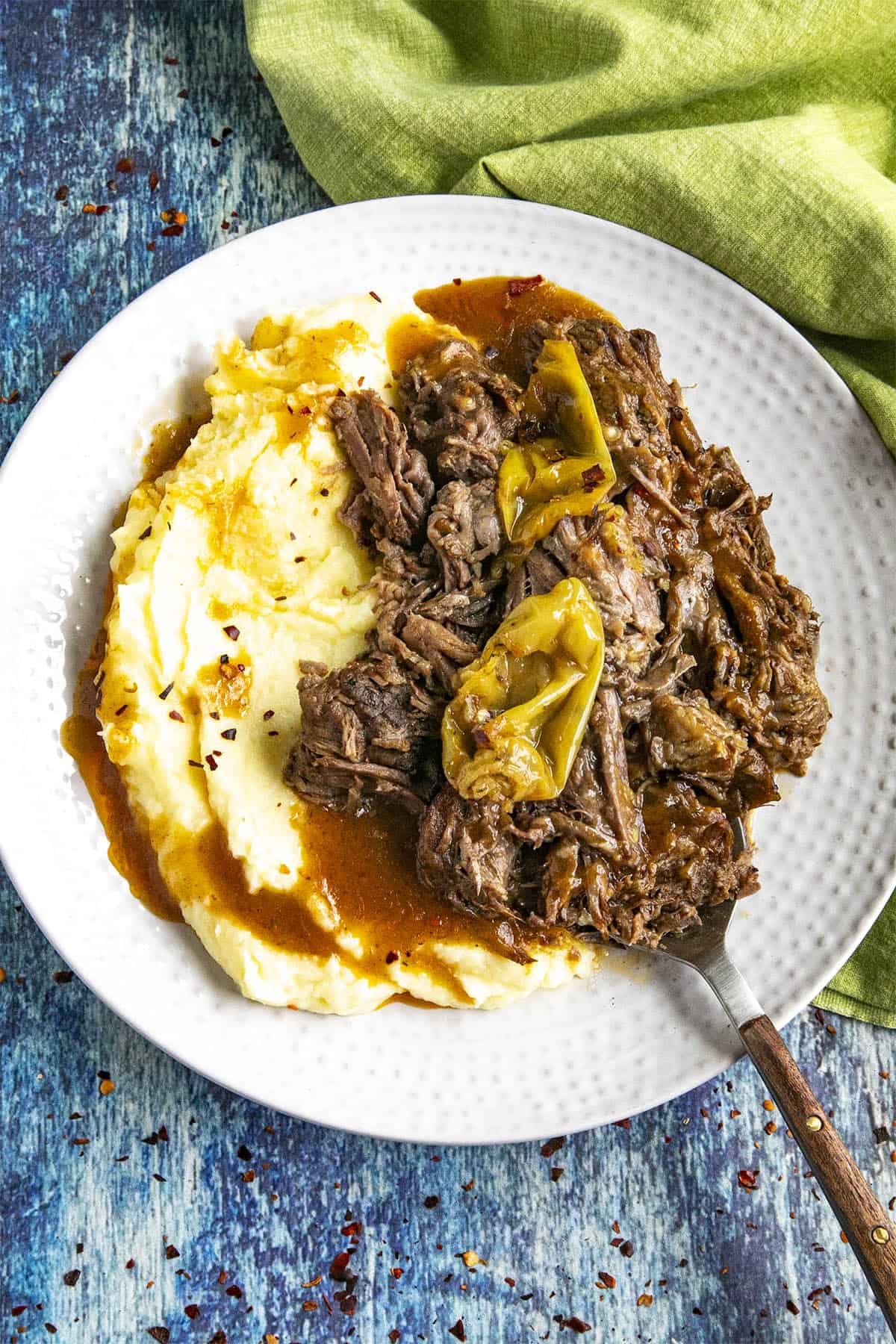 Mississippi Pot Roast on a serving plate with mashed potatoes and gravy