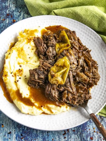 Mississippi Pot Roast on a serving plate with mashed potatoes