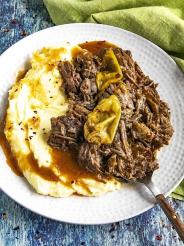 Mississippi Pot Roast on a serving plate with mashed potatoes